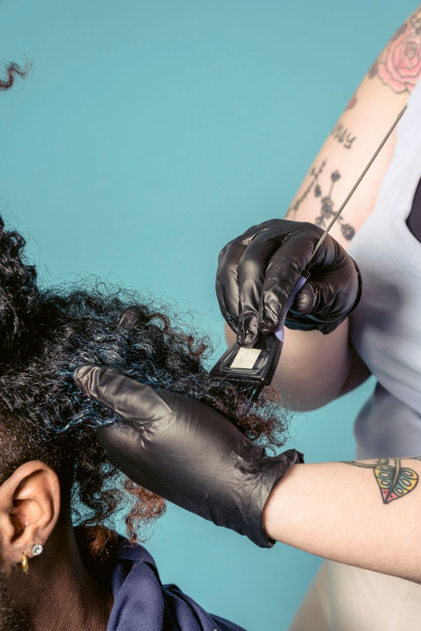 Representative close-up of a stylist applying hair color
