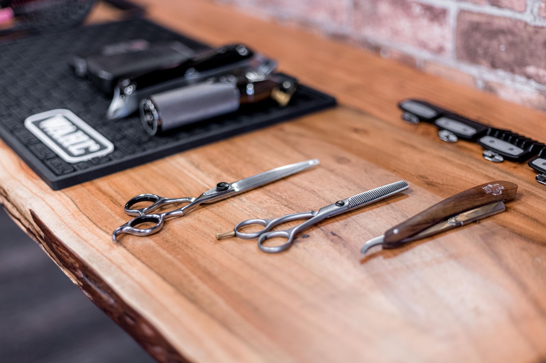Representative styling scissors and tools on a wooden surface